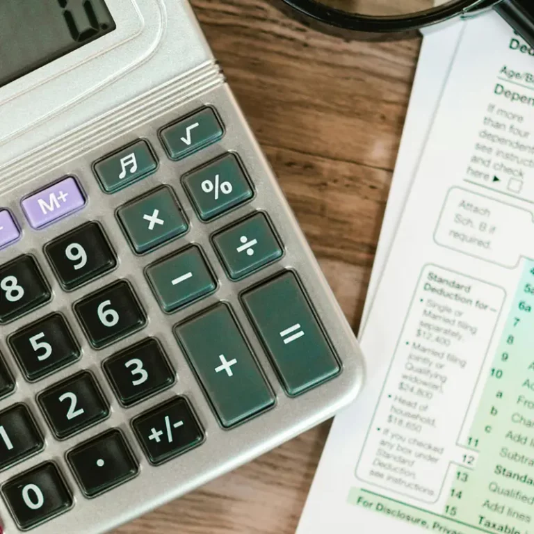 Une calculatrice et un formulaire d'impôts, illustrant la démarche pour déclarer les revenus issus de panneaux solaires