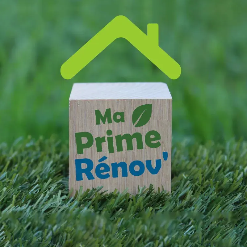Bloc en bois MaPrimeRénov posé sur de l’herbe, symbole des aides à la rénovation énergétique en France